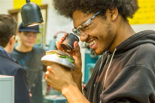 Demier Uses a Loupe to Inspect a Block of Lenses 